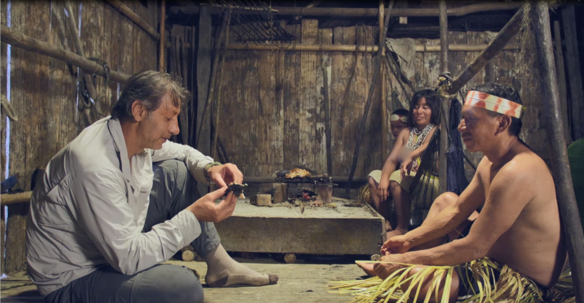 العتيبي يأكل أحد التماسيح التي قام باصطيادها مع قبائل الماتسيس