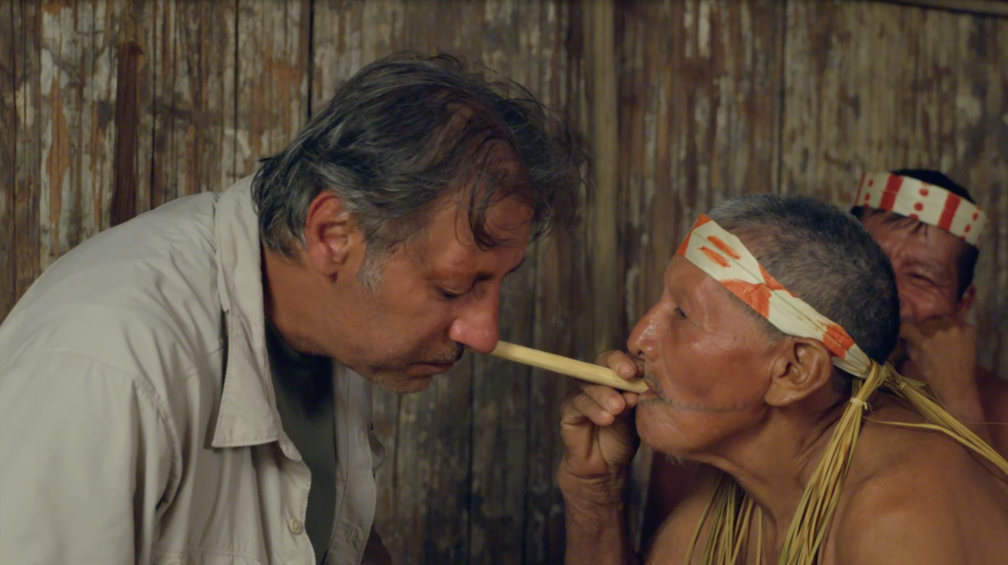 رجل من قبائل الماتسيس ينفخ في أنف العتيبي أحد أنواغ التبغ المعروف بالنيني الذي يعتقدون أنه يُزيل التعب